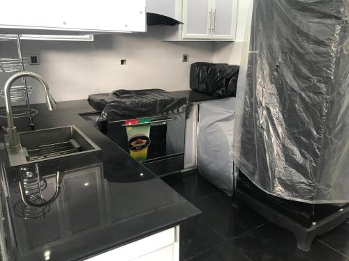 a kitchen with a black counter top and a sink at Guest House in Jhelum