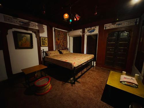 a bedroom with a bed and a table in it at The Prince Haveli in Bikaner
