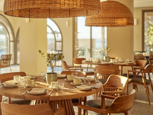 a dining room with tables and chairs and chandeliers at MarBella, Mar-Bella Collection in Agios Ioannis Peristeron