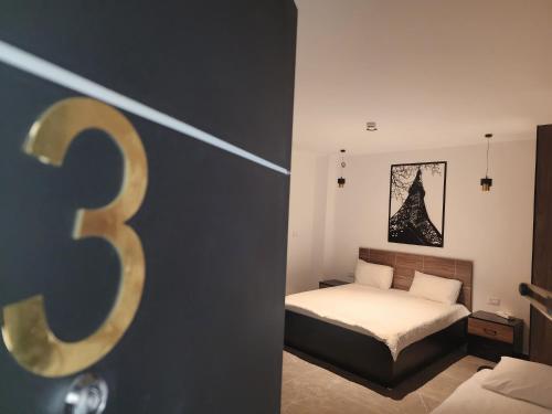 a bedroom with a bed with a number three at ZOZO Guesthouse in Nazareth