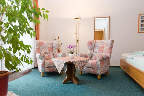 a living room with two chairs and a table at Haus Strandeck in Zingst