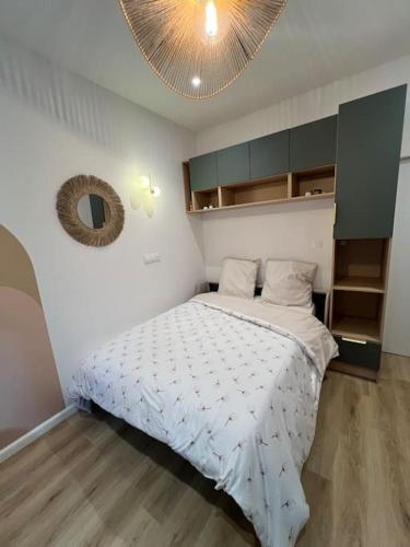 une chambre avec un lit et un miroir au mur dans l'établissement L Ecrin Nantais, à Nantes