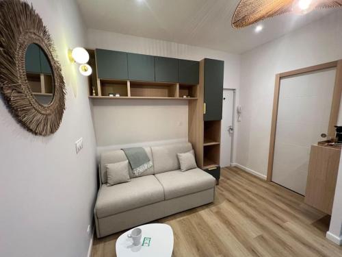 un salon avec un canapé et un miroir dans l'établissement L Ecrin Nantais, à Nantes