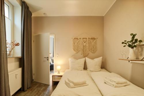 a bedroom with a large bed with white sheets and pillows at DTV-zertifizierte Ferienwohnung Kleine Moselruhe - zentral, für 3 Personen, Parkplatz & WLAN in Traben-Trarbach