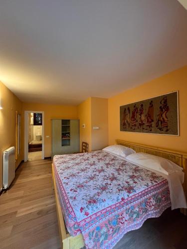 a bedroom with a large bed with a floral blanket at Rivarola al Tempo Dei Castelli in Carasco