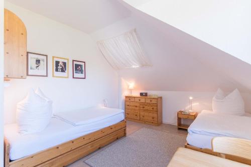 two beds in a room with white walls at Haus NÖCK in Wustrow