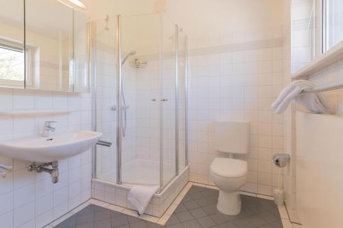 a bathroom with a shower and a toilet and a sink at Haus NÖCK in Wustrow