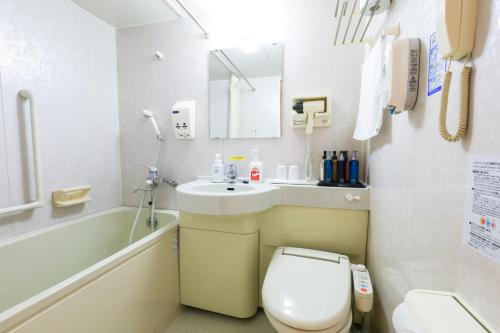 a bathroom with a toilet and a sink and a tub at Hill Hotel Sunpia Iga in Iga