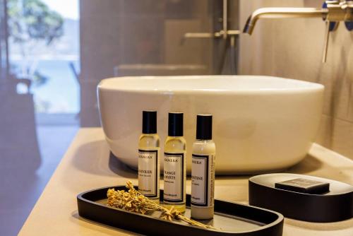 普罗普里亚诺Boutique hôtel Château Rouher的浴室的柜台上摆放着四瓶精油