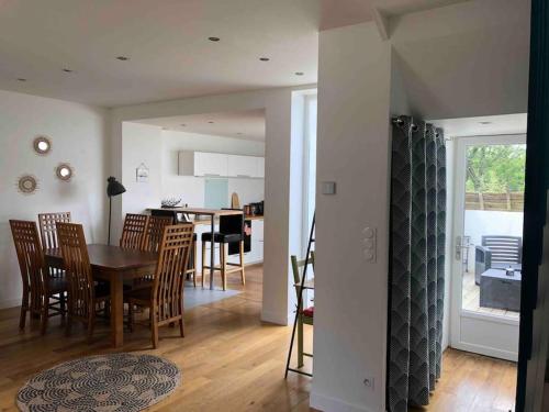 a kitchen and dining room with a table and chairs at Maison de ville conviviale avec terrasse in Lanester