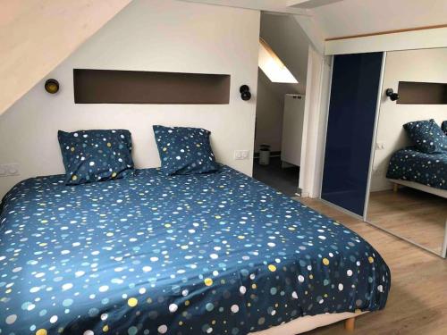a bedroom with a large bed with a blue comforter at Maison de ville conviviale avec terrasse in Lanester
