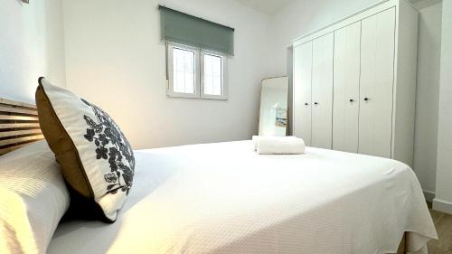 a bedroom with a large white bed and a mirror at SIBS Sanlúcar Guadalquivir I - TERRAZA in Sanlúcar de Barrameda