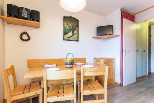 une salle à manger avec une table et des chaises en bois dans l'établissement Résidence La Pendule - Deux pièces sur le haut des Coches MAE-4984, à Aime La Plagne