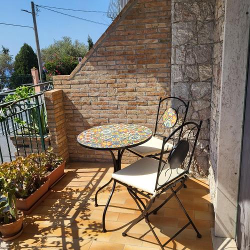 a patio with a table and chairs on a balcony at COCO Apartments Taormina in Taormina