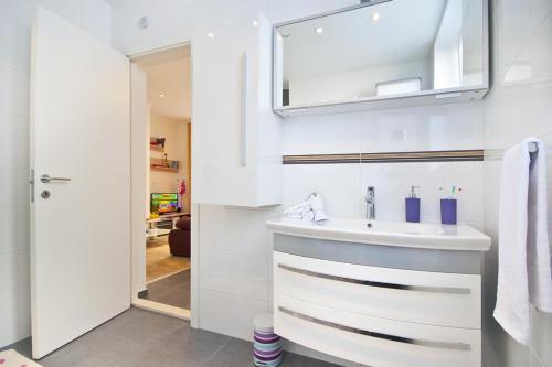 a white bathroom with a sink and a mirror at Mare et Silva Apartment Dubrovnik in Dubrovnik
