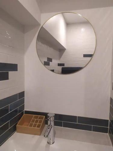 une salle de bain avec un miroir et un lavabo dans l'établissement Gîte avec jardin, à Légny