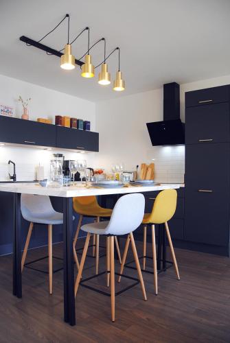 une cuisine avec une table et quatre chaises dans l'établissement Blue Sand - Appartement cosy-neuf à 500 m du bourg, à Saint-Philibert