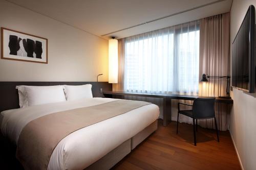 a hotel room with a large bed and a desk at Shilla Stay Gwanghwamun Myeongdong in Seoul