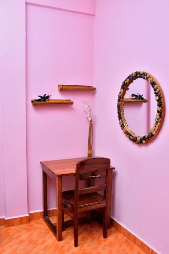 a table and a mirror on a pink wall at Hôtel de rêve Nosy Komba in Nosy Komba