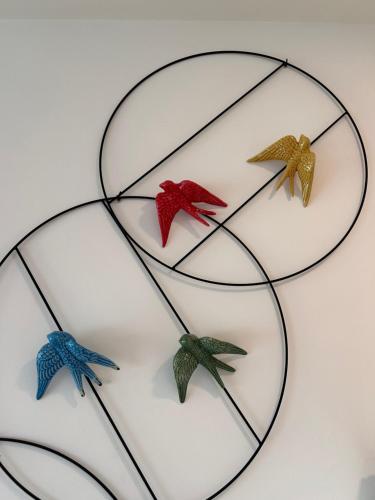 three birds are sitting on a glass shelf at Casa das Falcoeiras - AL com pátio e jardim privados in Aveiro