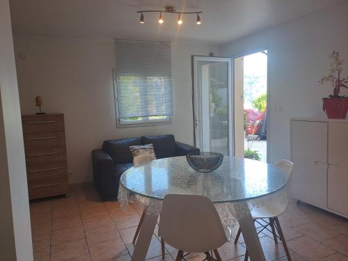 un salon avec une table en verre et des chaises dans l'établissement Loft 2, à La Trinité