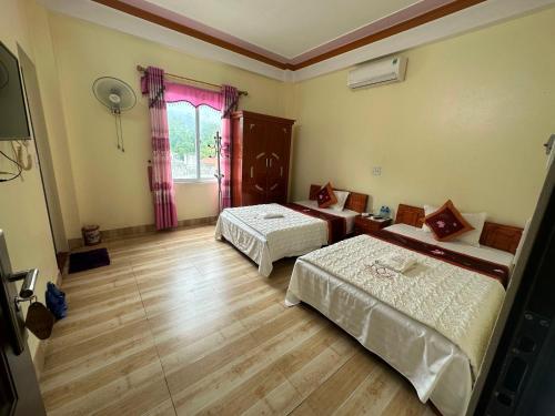 a room with two beds and a window at Kien Thao Hotel in Ha Giang