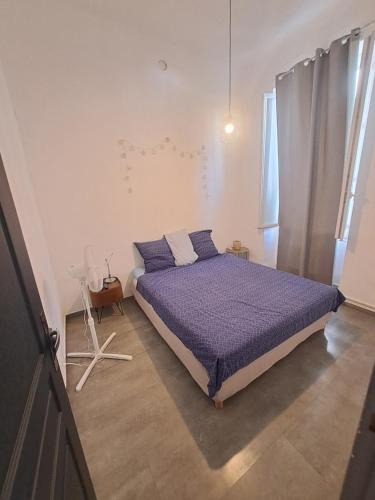une chambre avec un lit avec une couette violette dans l'établissement Au Méditerranéen, à Marseille