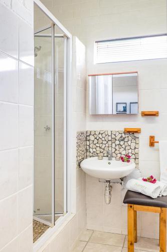 a white bathroom with a sink and a shower at Sea Villa Vista in St. Helena Bay