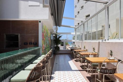 a restaurant with tables and chairs next to a swimming pool at Jewel TLV Hotel in Tel Aviv