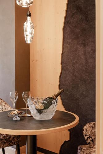 a table with a bowl of wine glasses on it at Cerana Relax Hotel in Madonna di Campiglio