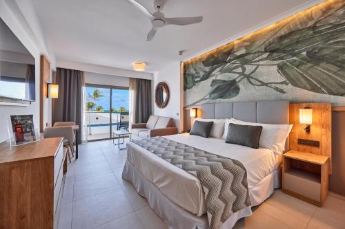 a bedroom with a large bed and a living room at Riu Palace Mauritius - All Inclusive - Adults Only in Le Morne