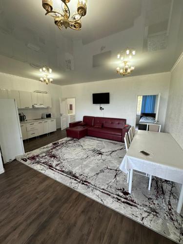 a living room with a red couch and a table at Симирам! in Korumdy
