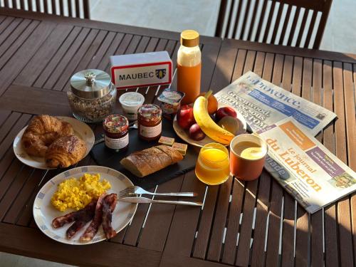 een tafel met ontbijtproducten en drankjes erop bij La Provence in Maubec