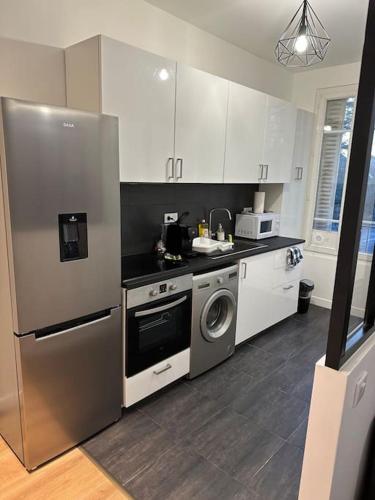 La cuisine est équipée d'un réfrigérateur en acier inoxydable et d'un lave-vaisselle. dans l'établissement Modernité proche de Paris et du Stade de France, à Pierrefitte-sur-Seine