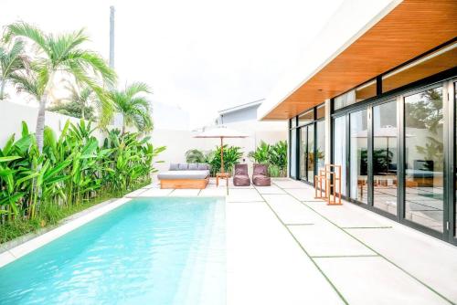 an infinity pool in a house with palm trees at 99 Villa Suite - Modern Bedrooms with Dining Area & Enormous Pool in Kerobokan