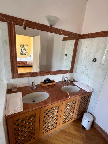 a bathroom with two sinks and a large mirror at Rivarola al Tempo Dei Castelli in Carasco