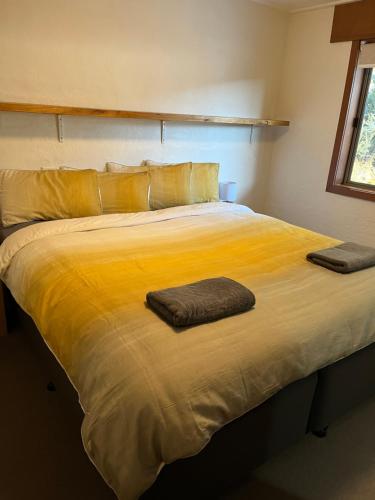 a large yellow bed with two pillows on it at Ripparoo Lodge in Falls Creek