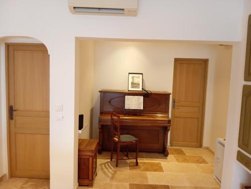une entrée dans une pièce avec un piano à queue dans l'établissement Villa Gabriel, à Goult