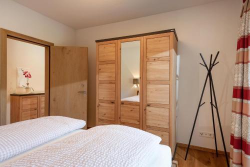 a bedroom with a bed and a cabinet with a mirror at Appartement Alpenfieber in Söll