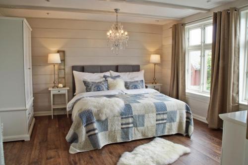 a bedroom with a bed and a chandelier at Alnes Gård in Ålesund