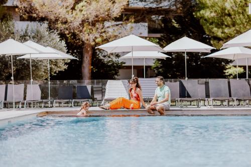 a group of people sitting in a swimming pool at Novotel Montpellier in Montpellier