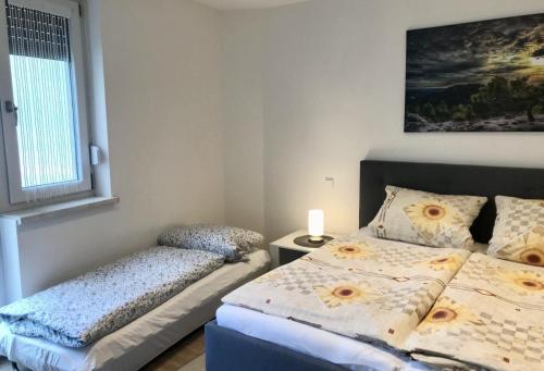 a bedroom with two beds and a window at Ferienwohnung Altstadtherz in Tirschenreuth