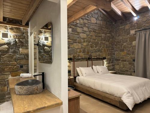 a bedroom with a bed and a stone wall at Άνδηρο in Synikia Mesi Trikalon