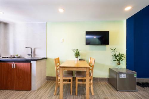 a kitchen with a table with chairs and a sink at Gemini Saigon CENTER - New & Quiet near Bui Vien Walking Street in Ho Chi Minh City