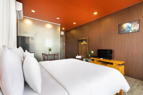a bedroom with a large white bed and a television at Gemini Saigon CENTER - New & Quiet near Bui Vien Walking Street in Ho Chi Minh City