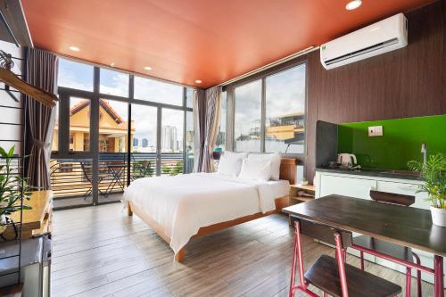 a hotel room with a bed and a desk and windows at Gemini Saigon CENTER - New & Quiet near Bui Vien Walking Street in Ho Chi Minh City