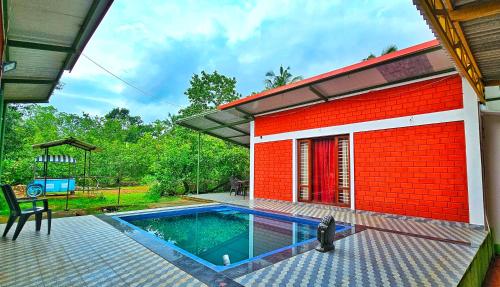 a house with a swimming pool in front of it at Farmhouse with Pool - Kalavady Farmstay in Baindūru