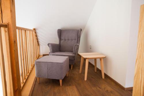 a chair and a stool in a room with a table at Prázdninový dům Těchobuz in Těchobuz