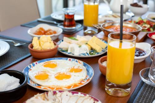 a table with plates of breakfast food and orange juice at Hotel du Bois d'Arlon in Arlon