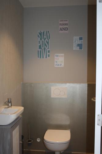 a bathroom with a toilet and a sink at Appartement Duplex Au Chat'rme des Blanches Pierres in Francorchamps